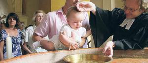 Pfarrer Matthias Mieke tauft die kleine Emily am Springbrunnen vor der Friedenskirche. Vier Orte waren auserkoren worden, um die erste Potsdamer Gemeinschaftstaufe zu zelebrieren. Danach wurde gemeinsam im Atrium der Kirche gefeiert.