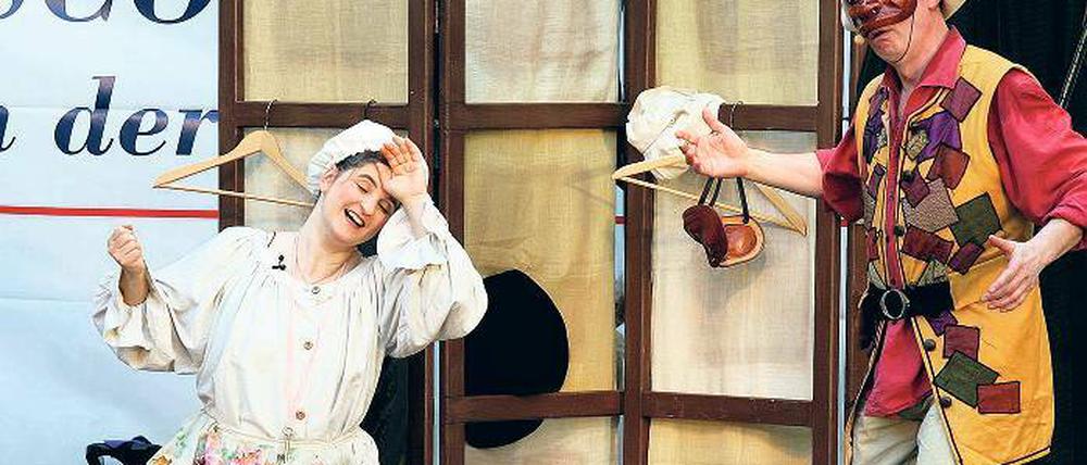 Am Paravant hängen Kostüme und Masken  mehr Requisiten braucht es nicht für die komödiantischen Szenen, in denen Commedia dellarte vorgestellt wird.