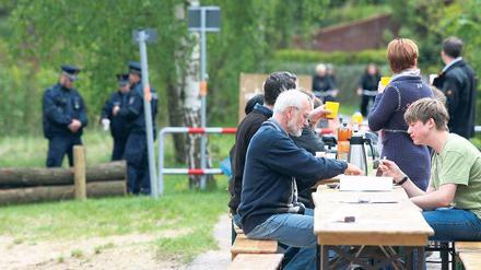 Unter Polizeischutz. Friedliche Picknicker am Samstag auf dem ehemaligen Mauerstreifen an der Badewiese in Groß Glienicke. Ihr Ziel ist ein freier Uferweg.