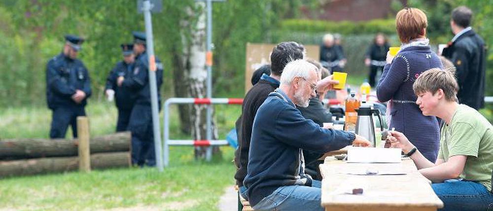 Unter Polizeischutz. Friedliche Picknicker am Samstag auf dem ehemaligen Mauerstreifen an der Badewiese in Groß Glienicke. Ihr Ziel ist ein freier Uferweg.