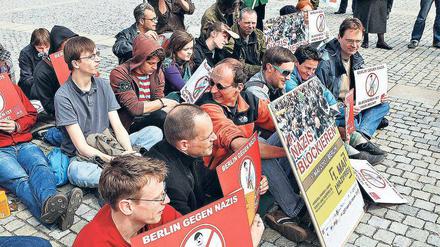 Spielfigur mit Hitler-Bärtchen. Das Bündnis 1. Mai  Nazifrei übte am Bebelplatz das Besetzen von Wegen und zeigte dabei auch gleich die neuen Plakate.