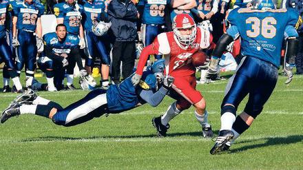 Einsatz im entscheidenden Spiel. Touch-Down-Man Lutz Nichelmann (Mitte) kämpft sich hier durch die Abwehrkette der Rostock Griffins. Am Ende gewann sein Potsdamer Team mit 13:6.