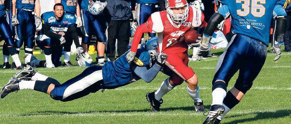 Einsatz im entscheidenden Spiel. Touch-Down-Man Lutz Nichelmann (Mitte) kämpft sich hier durch die Abwehrkette der Rostock Griffins. Am Ende gewann sein Potsdamer Team mit 13:6.