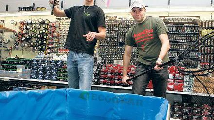 In einem Wasserbecken können Angelsport-Fans bei AngelJoe ab heute die neuesten Kunstköder sofort testen; Jonas F. Müller (r.) und Julian Straßburg zeigen mit viel Spaß, wie es geht.