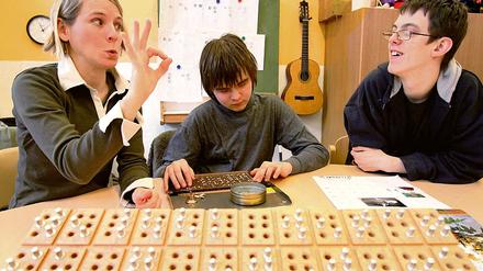 Kommunikativer Fingerzeig. Miriam Winter (l.) ist eine von 25 Sonderpädagoginnen an der Babelsberger Oberlinschule. Die Kommunikation zwischen Schülern und Lehrer geschieht oft mittels der Gebärdensprache, hier spricht Winter zu den hörsehbehinderten Schülern Gerard und Edi (M.).