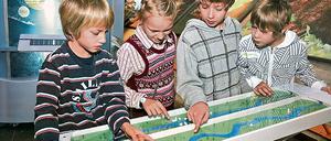 Achtung, Hochwasser! Philip, Alma, Jan und Nils (v.l.) überschwemmen das Modell einer Flusslandschaft mit Kleinstadt.