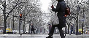 Rutschgefahr. Mit vorsichtigen Schritten überquerte eine Fußgängerin am Dienstag eine spiegelglatte Straße in Berlin, nachdem Regen die Fahrbahn mit einer Eisschicht überzogen hatte.