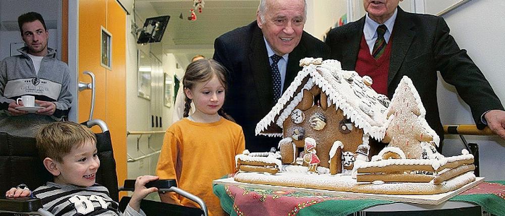 Wie von den Brüdern Grimm gebacken: Ex-Ministerpräsident Manfred Stolpe und Peter Kretschmer, Geschäftsführer des Instituts für Getreideverarbeitung, brachten gestern ein Lebkuchenhaus in die Kinderklinik  sehr zur Freude von Luca und Antonia.