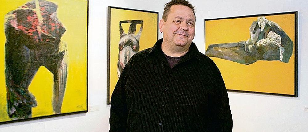 Stephan Velten in der Ausstellung im Potsdam-Museum vor seinem Zyklus Gelbe Torsi, gemalt 1989. Zu sehen sind auch die Kohlezeichnungen Bleierne Zeit und Große Figur von 1989/ 88 (l.) sowie seine Helden (r.), mit denen er sich gegenwärtig beschäftigt und die junge Menschen zeigen, die sich im Krieg verheizen lassen.