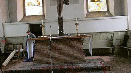 Vorher und Nachher  links vom Altar ist bereits die dicke Rußschicht auf dem Fußboden der Teltower Andreaskirche beseitigt worden.
