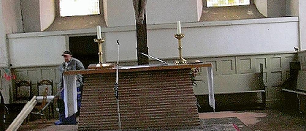 Vorher und Nachher  links vom Altar ist bereits die dicke Rußschicht auf dem Fußboden der Teltower Andreaskirche beseitigt worden.