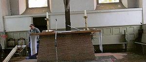 Vorher und Nachher  links vom Altar ist bereits die dicke Rußschicht auf dem Fußboden der Teltower Andreaskirche beseitigt worden.