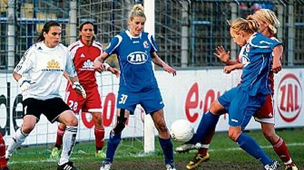 2:2 am 1. April 2009. Babett Peter schießt, Anja Mittag und Nadine Angerer (v. r.) sind zum Eingreifen bereit.