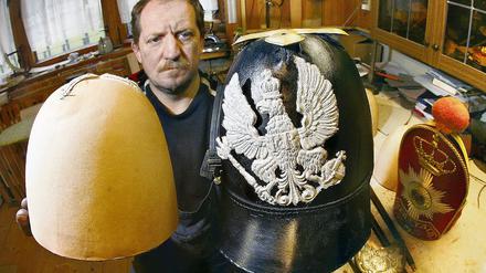 Hobbyhistoriker und Uniformmacher. Gert Kinnemann präsentiert in seiner Werkstatt eine noch unfertige Pickelhaube (r.) und einen Rohling. Der Neuenhagener Autodidakt kann auch zu jedem Kostüm-Detail geschichtliche Erläuterungen geben.