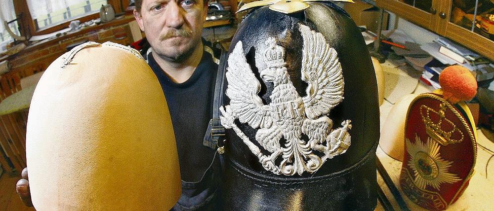 Hobbyhistoriker und Uniformmacher. Gert Kinnemann präsentiert in seiner Werkstatt eine noch unfertige Pickelhaube (r.) und einen Rohling. Der Neuenhagener Autodidakt kann auch zu jedem Kostüm-Detail geschichtliche Erläuterungen geben.