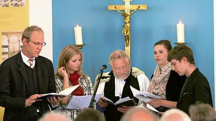 Sie sprachen gestern Abend das Nagelkreuzgebet: Stadtkirchenpfarrer Markus Schütte (l.), Reverend Robin Youett und Mitglieder der Jungen Gemeinde der Friedenskirche .