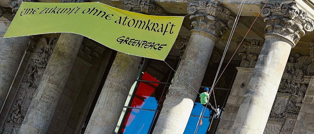 Gegen Atomkraft. Ein Greenpeace-Mitglied mit dem Plakat am Reichstag.