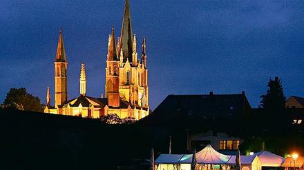 Die spitzenreiche neugotische Heilig-Geist-Kirche in Werder in abendlicher Illumination.