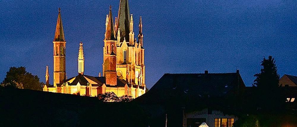 Die spitzenreiche neugotische Heilig-Geist-Kirche in Werder in abendlicher Illumination.