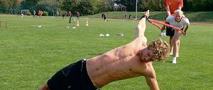 Trockentraining in Potsdam. Hendrik Feldwehr, Jaana Ehmcke und Yannik Lebherz (oben von vorn) bei einer der spezifischen Übungen, die Homayun Gharavi zum Teil selbst vormacht (unten rechts). Bundestrainer Dirk Lange  links beim Interview mit Potsdam TV  kam mit seinem Team gern in den Luftschiffhafen, in dem die beiden OSC-Schwimmer Jaana Ehmcke und Felix Wolf (Fotos unten in der Mitte) gestern auf Waveboards eine unterschiedlich gute Figur machten.