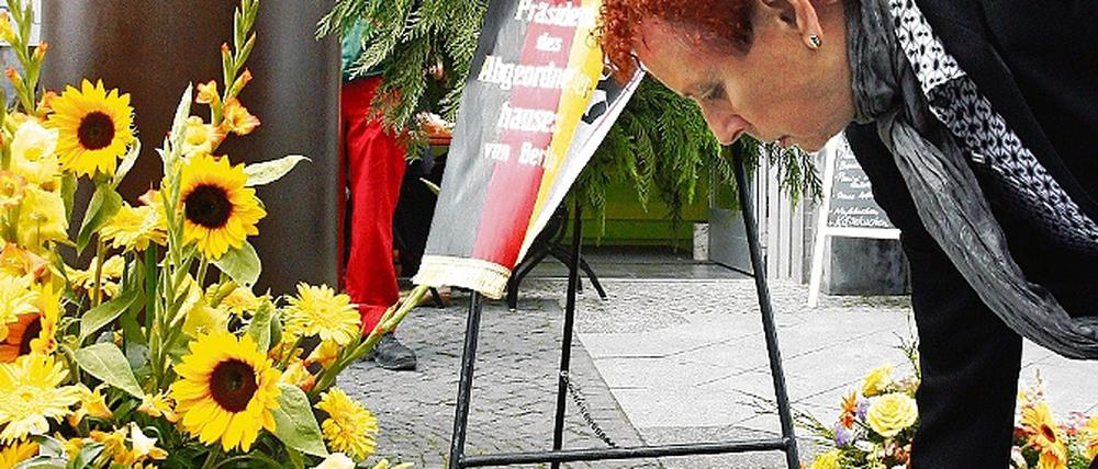 Gisela Geue, Schwester des erschossenen Peter Fechter, legt am Fechter-Mahnmal Blumen nieder.
