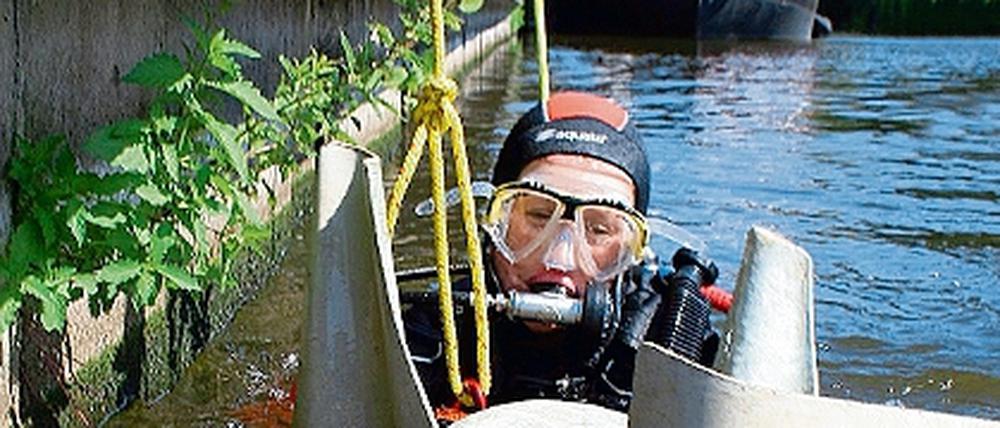 Einen Plastik-Stuhl holt der Taucher vom Grund der Alten Fahrt. Wasserretter der DLRG säuberten für das Inselschwimmen am Samstag das Gewässer.
