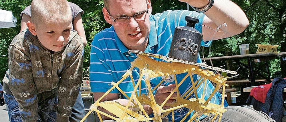 Zum Einsturz verdammt - Frank Pagenkopf von der Potsdamer Universität hat mit den Camp-Kindern Nudelkonstruktionen zusammengeleimt und prüft nun deren Statik. Wieviel Kilo werden die Gebilde tragen ohne einzustürzen?