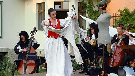Schaufensterpuppentorso und Melone, fertig ist der Don Quixote. Friederike Rinne-Wolf umgarnt den Ritter, im Hintergrund spielen die Musiker von Celeste Sirene.