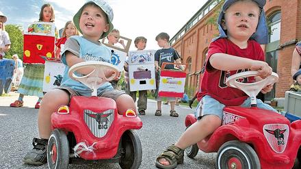 Papp-Autos brauchen keine Stellfläche. Familien protestieren mit ihren Kindern gegen die weitere Bebauung.