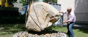 7,5 Tonnen Granit werden als Findling in den Hof des Naturkundemuseums eingeschwebt. Der Geschäftsführer der Bauzuschlagstoffe und Recycling GmbH, Götz Eckert, will ihn in die passende Kuhle dirigieren.