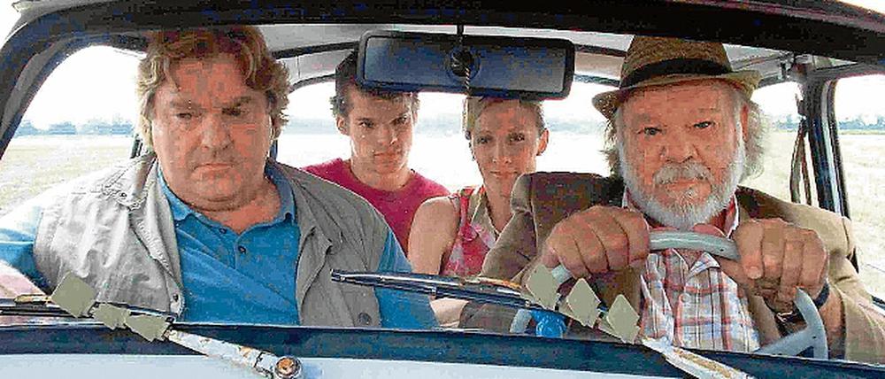 Im Trabi übers Land. Der arbeitslose Rosenow (Hans Jürgen Alf, l.) unterstützt Lehrerin Frau Frei (Anja Karminski, hinten rechts) beim DDR-Anschauungsunterricht.