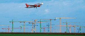 Hochfliegende Pläne. Ein Passagierflugzeug über den Kränen der größten Flughafenbaustelle Europas in Schönefeld. Der neue Flughafen BBI soll 2,2 Milliarden Euro kosten und 2011 in Betrieb gehen.