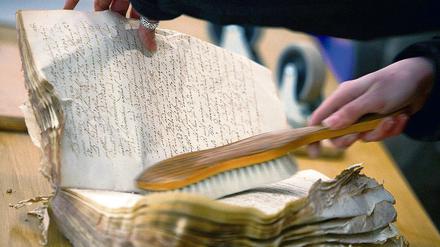 Gebürstet und von Staub befreit werden die Bücher aus dem Kölner Archiv.