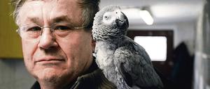 Hans-Jürgen Fengler posiert mit dem Graupapagei Julchen auf der Schulter.
