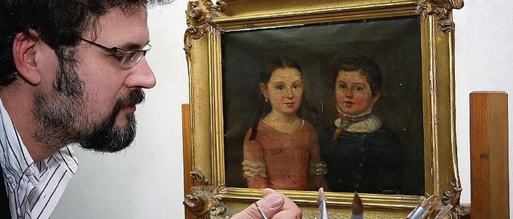 Restaurator Oliver Wenske nimmt sich des Porträts des Bankers Julius Kann mit seiner Schwester von 1849 an.