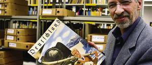 Der Leiter des Archivs für Tourismus, Hasso Spode, zeigt eine historische Ausgabe der Zeitschrift Deutschland.