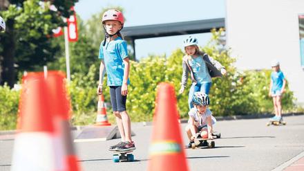 Sicher mit Helm. Keela hockt noch auf ihrem Longboard, bald wird sie aber wie die anderen Kinder, die bei der Aktion „OnBoard“ mitmachen, sicher stehend fahren können.