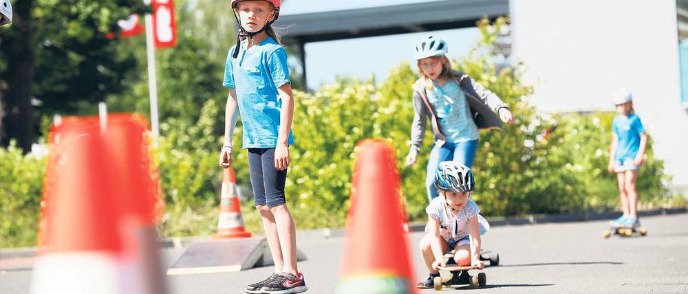 Sicher mit Helm. Keela hockt noch auf ihrem Longboard, bald wird sie aber wie die anderen Kinder, die bei der Aktion „OnBoard“ mitmachen, sicher stehend fahren können.