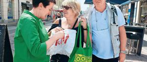 Umweltaktion. OB-Kandidatin Armbruster (l.) gibt einen Stoffbeutel aus.