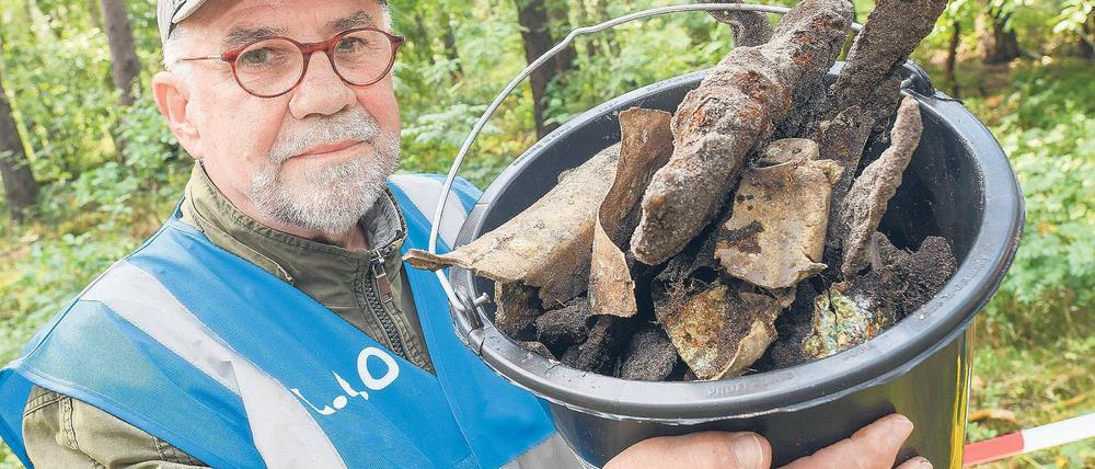 Spurensuche. Hobbyforscher Gerhard Kaminski zeigt in einem Waldstück bei Briesen (Oder-Spree) einen Eimer mit ersten Fundstücken von einem sowjetischen Kampfflugzeug IL-2, das hier im Zweiten Weltkrieg abstürzte. Luftfahrtarchäologen waren über Zeitzeugenangaben auf den Fund gestoßen.