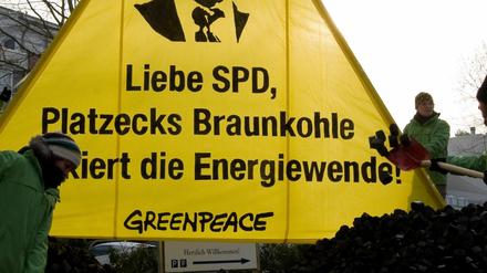 Aktivisten der Umweltschutzorganisation Greenpeace schaufelten am Sonntag (29.01.12) auf der Halbinsel Hermannswerder in Potsdam unter einem Transparent mit der Aufschrift "Liebe SPD, Platzecks Braunkohle blockiert die Energiewende!" Kohlebriketts auf einen Haufen, um die Zufahrt zum Inselhotel zu blockieren, wo sich die SPD zu ihrer Klausurtagung treffen will. Greenpeace will damit gegen den nach ihrer Ansicht klimaschaedlichen Kohlekurs des brandenburgischen Ministerpraesidenten protestieren.