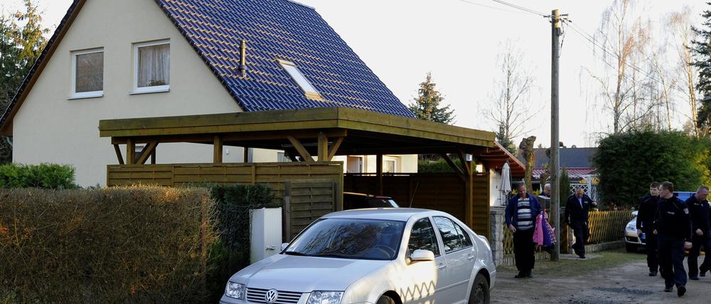 Polizisten gehen am Sonntag (25.03.12) in Brieslang vor einem Haus, in dem eine Frau erstochen wurde.
