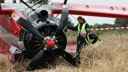 Mitarbeiter der Bundesstelle für Flugunfalluntersuchung (BFU) begutachten am 11.08.2013 auf einem Kornfeld in der Nähe von Paulinenaue (Brandenburg) died abgestürzte Propellermaschine. An Bord sollen zu viele Passagiere gewesen sein.