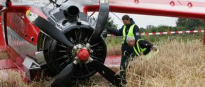 Mitarbeiter der Bundesstelle für Flugunfalluntersuchung (BFU) begutachten am 11.08.2013 auf einem Kornfeld in der Nähe von Paulinenaue (Brandenburg) died abgestürzte Propellermaschine. An Bord sollen zu viele Passagiere gewesen sein.
