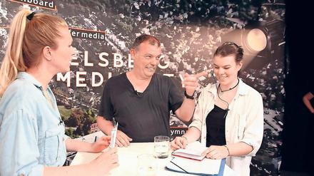 Wie die Profis. In kurzen Pausen erklärt Schülerin Jule Stegner (rechts), die für die Aufzeichnung die Studio-Regie übernommen hat, Moderatorin Anni Dunkelmann (links) und Filmproduzent Tom Zickler, wie es weitergeht. Die Zehntklässler des Babelsberger Filmgymnasiums haben am Mittwoch ihre erste Sendung produziert.