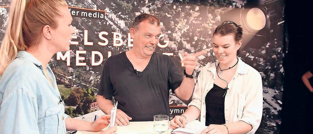 Wie die Profis. In kurzen Pausen erklärt Schülerin Jule Stegner (rechts), die für die Aufzeichnung die Studio-Regie übernommen hat, Moderatorin Anni Dunkelmann (links) und Filmproduzent Tom Zickler, wie es weitergeht. Die Zehntklässler des Babelsberger Filmgymnasiums haben am Mittwoch ihre erste Sendung produziert.