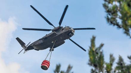Wasser! Ein Hubschrauber der Bundeswehr transportiert Löschwasser über dem ehemaligen Truppenübungsplatz in Südbrandenburg. Nach dem Großbrand vor wenigen Tagen brennt es in der Lieberoser Heide erneut.