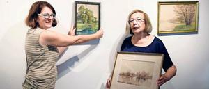 Teamarbeit. Carola Pauly (l.) und Jelena Jamaikina (r.) hängen die letzten Bilder für die Jubiläumsausstellung auf. Im Museumsverein packt jeder gern mit an.