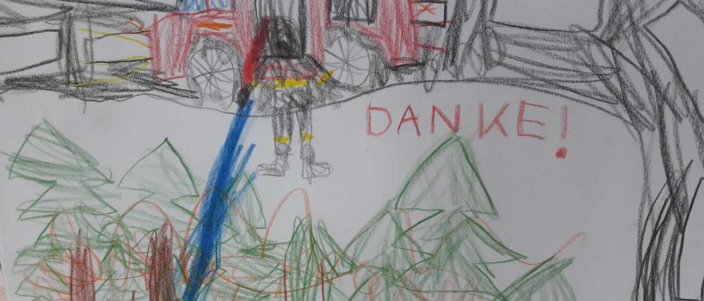 Auch die Kleinen danken der Feuerwehr. Eine Mutter hat das Bild ihres Kindes an Fichtenwaldes Ortsvorsteher Tilo Köhn gesendet. Im Ort hängen mehrere ähnliche Zeichnungen an Laternen- und Schildermasten, die den etwa 1200 zumeist ehrenamtlichen Feuerwehrleuten die Wertschätzung der Bewohner zeigen sollen.