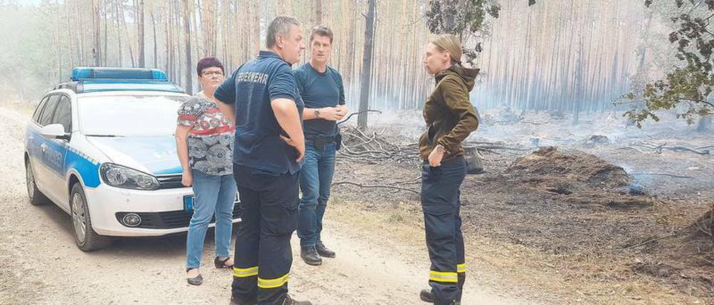 Spurensuche. Kommissar Frank Tiews (Mitte) lässt sich von den Feuerwehrleuten Olaf Fetz und Ulrike Fischer zeigen, wo der Brand hinter Frohnsdorf ausbrach.